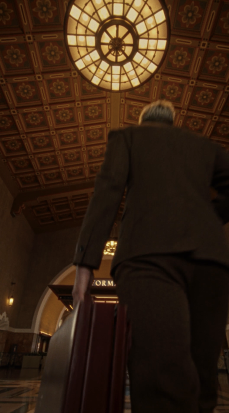 Low angle of a man walking beneath an ornate domed ceiling