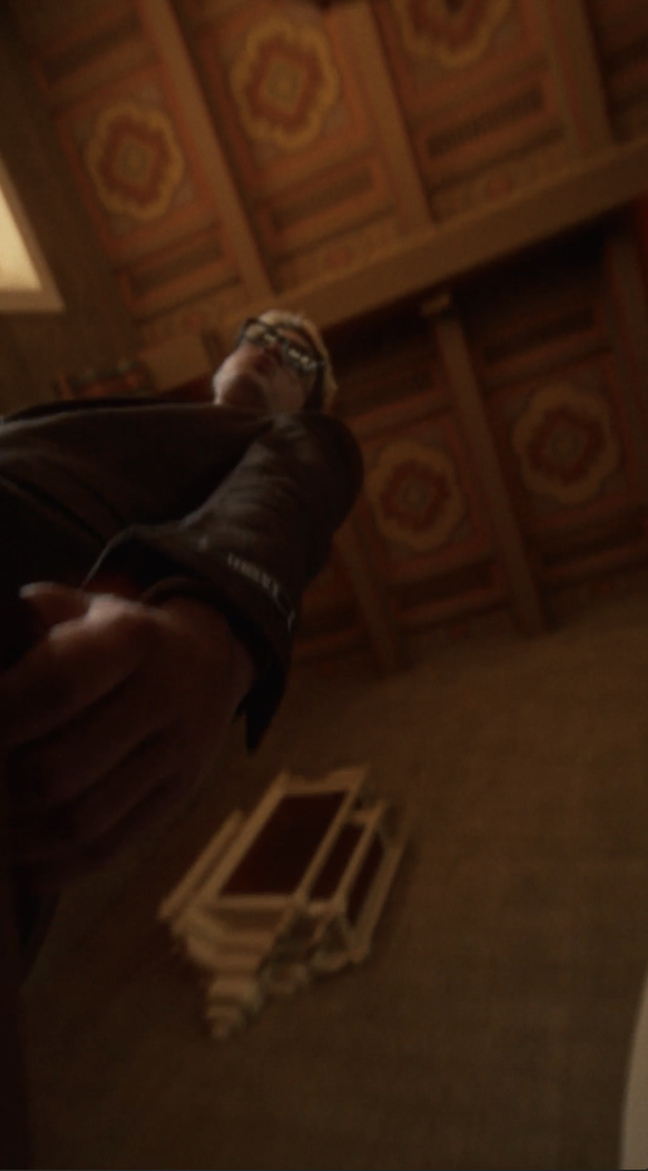 Dutch angle of a woman in a grand tiled hall